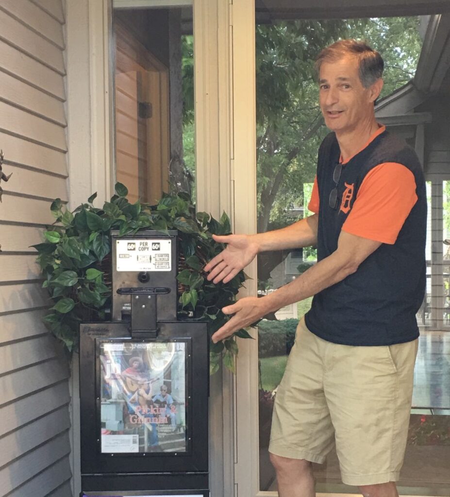 Arthur Horwitz showing an old newspaper box, commemorating the 75th anniversary of the Detroit Jewish News.