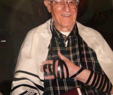 Elderly Jewish man wearing tefillin during morning prayer