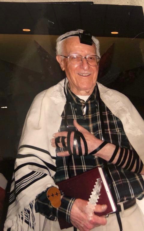Elderly Jewish man wearing tefillin during morning prayer